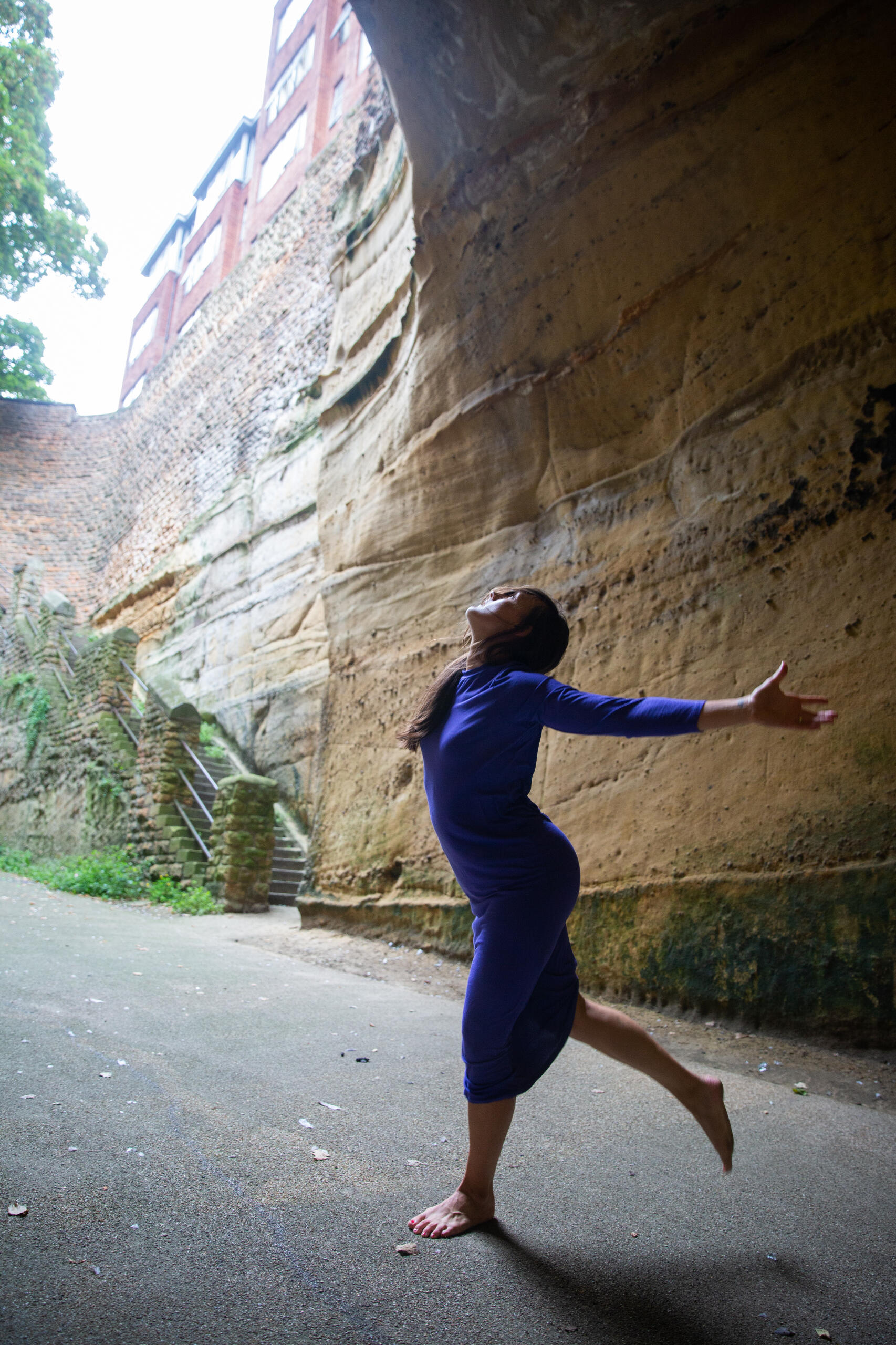 Karla dancing in front of a stone wall