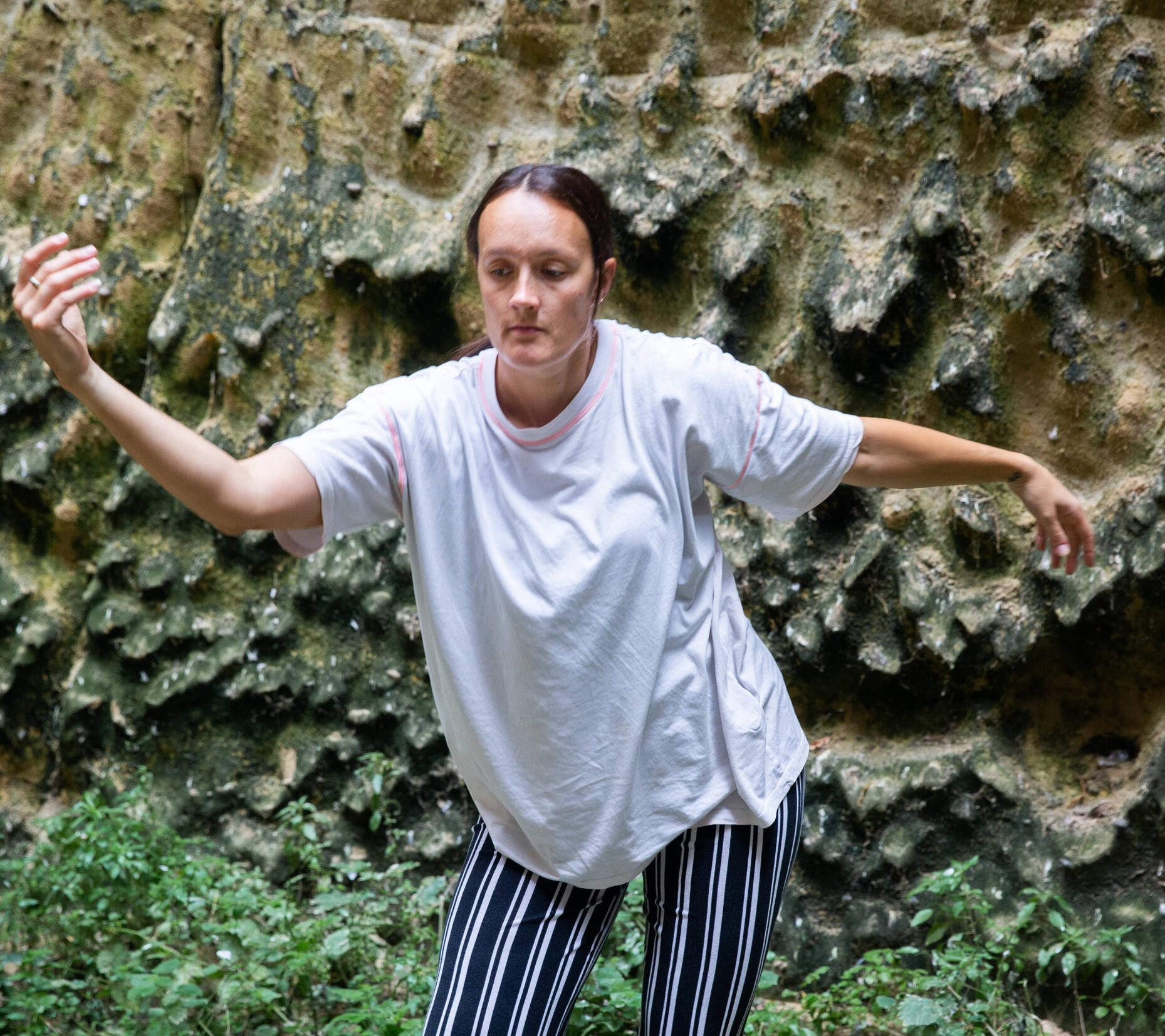 Karla dancing in front of a stone wall
